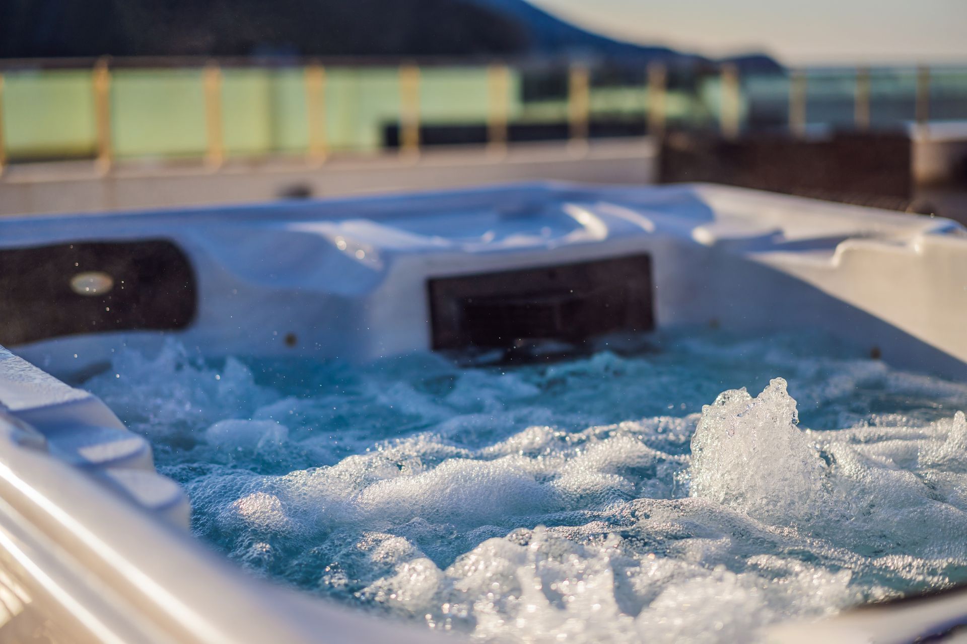 Foaming bubbles in a hot tub with built-in headrests at sunset