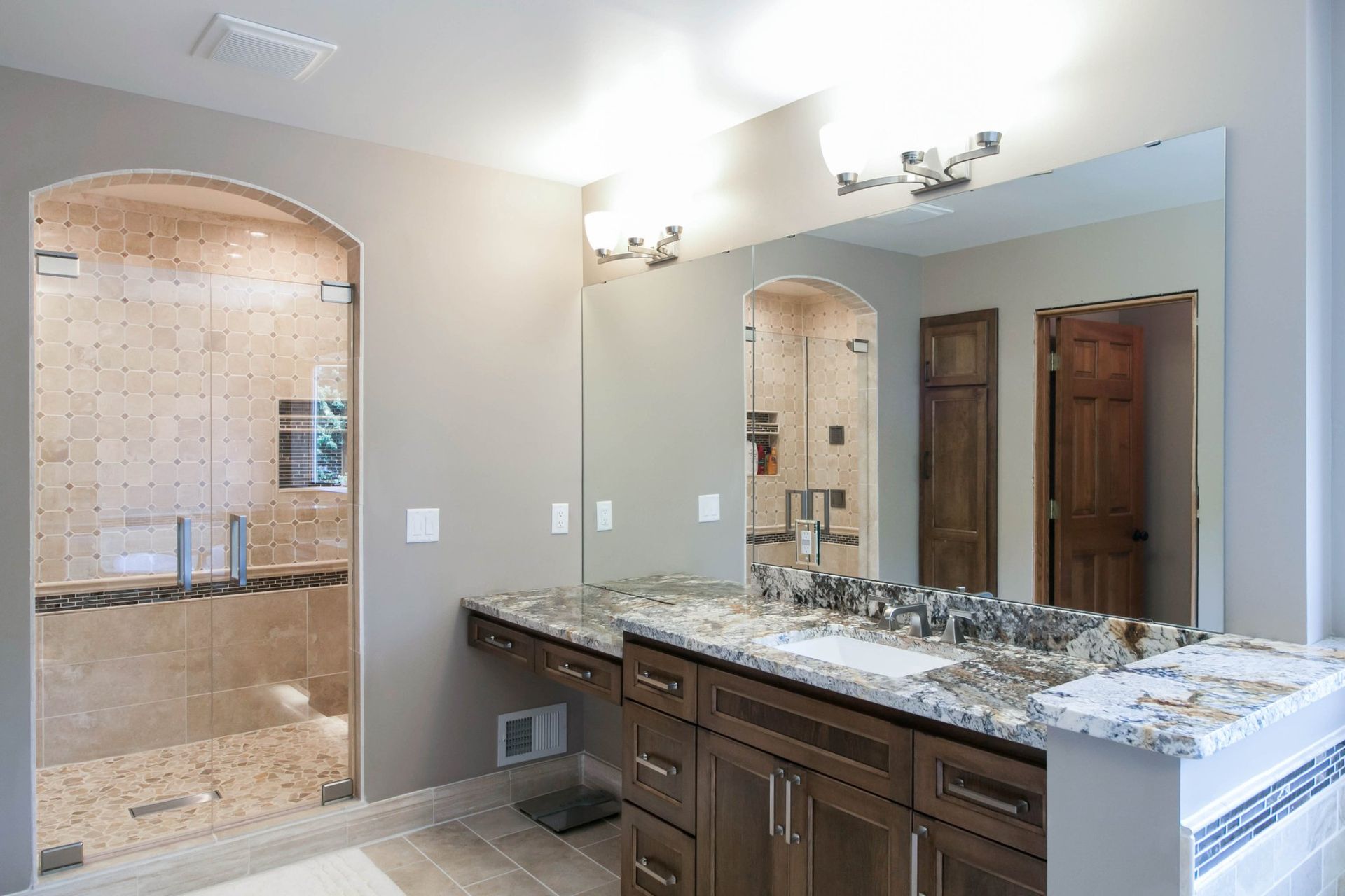 A bathroom with two sinks and a large mirror.