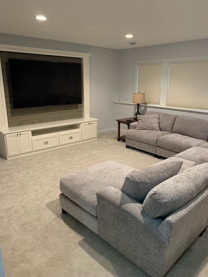A living room with a large sectional couch and a flat screen tv.