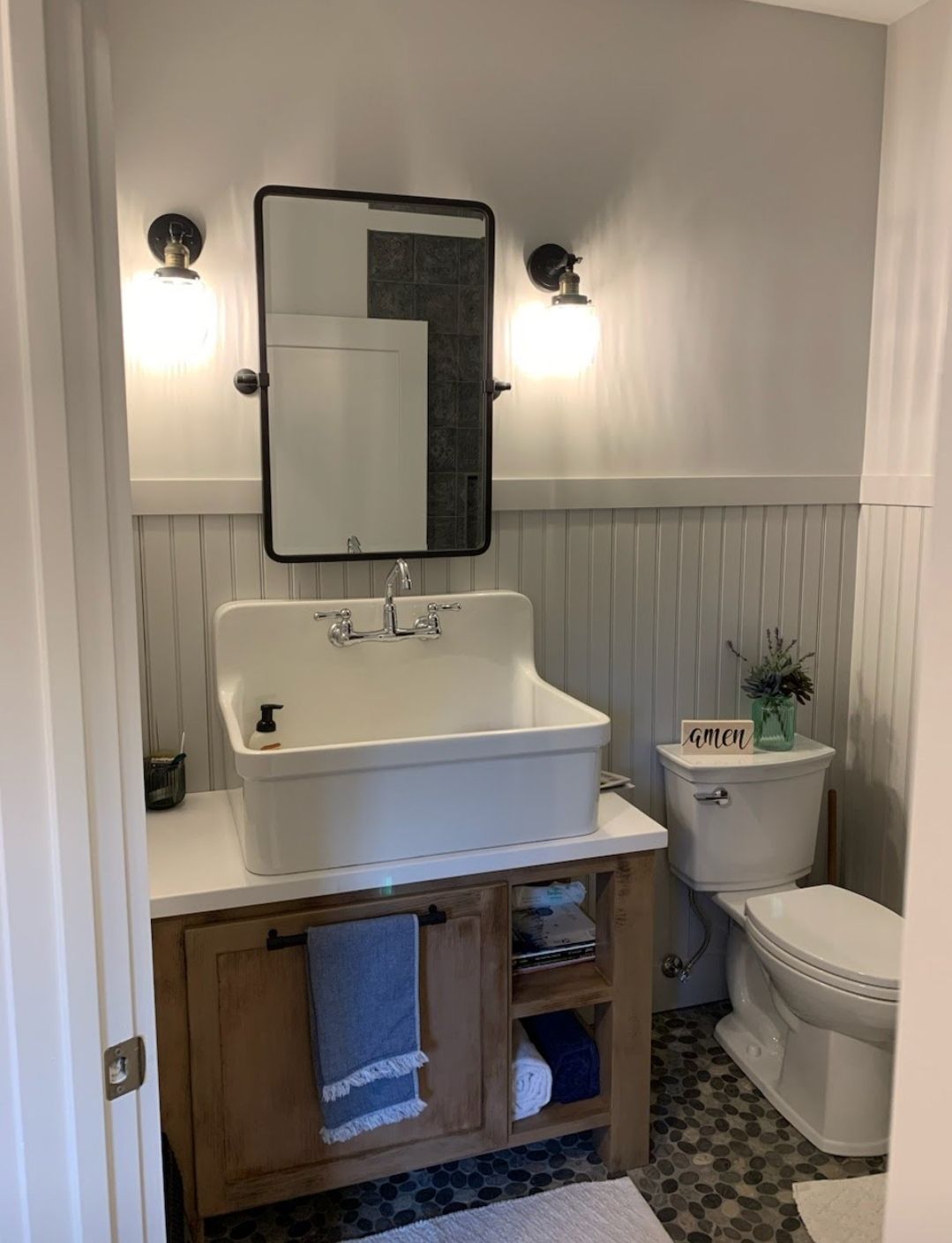 A bathroom with a sink , toilet and mirror.