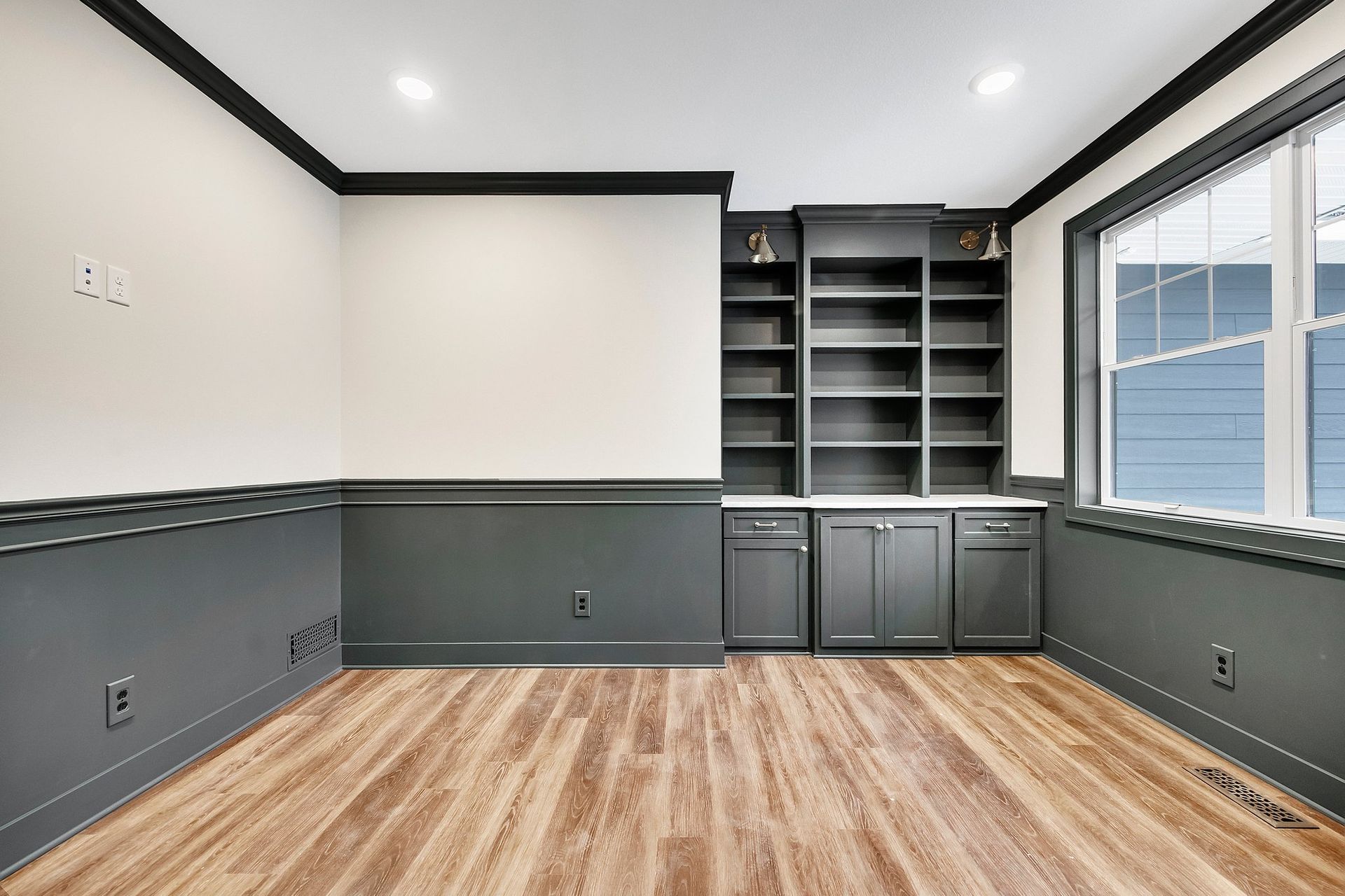 An empty room with hardwood floors and built in shelves.