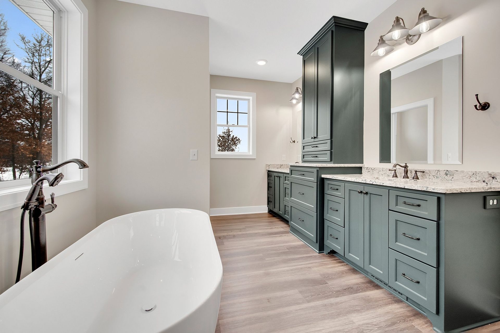 A bathroom with a tub , sink , mirror and cabinets.