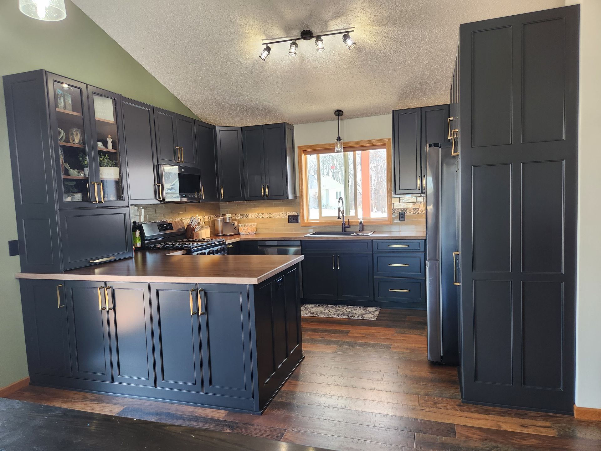 A kitchen with black cabinets and a large island