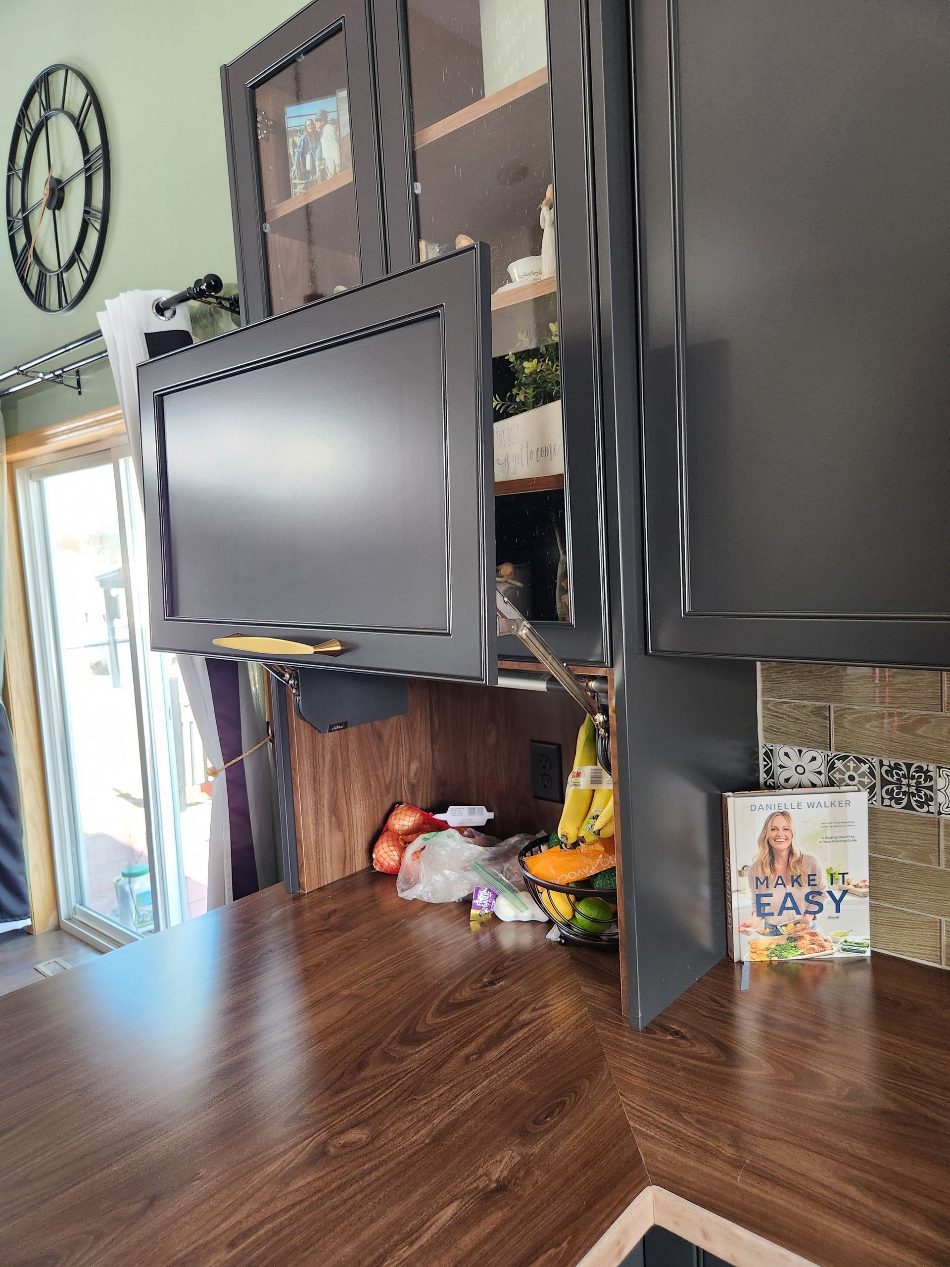 A kitchen counter with a tv and a book on it.
