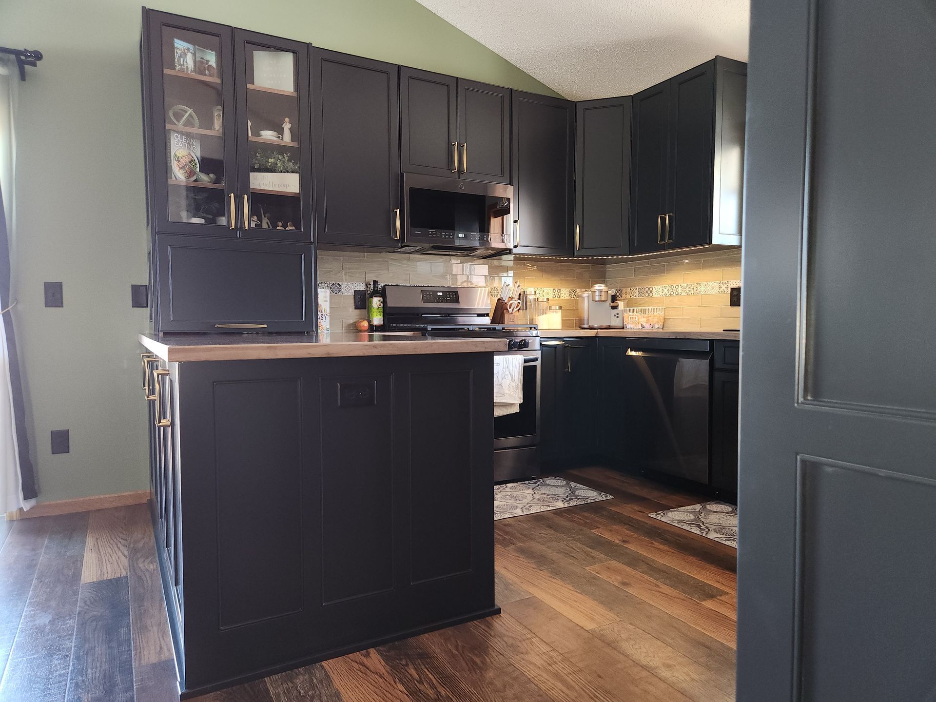 A kitchen with black cabinets and stainless steel appliances