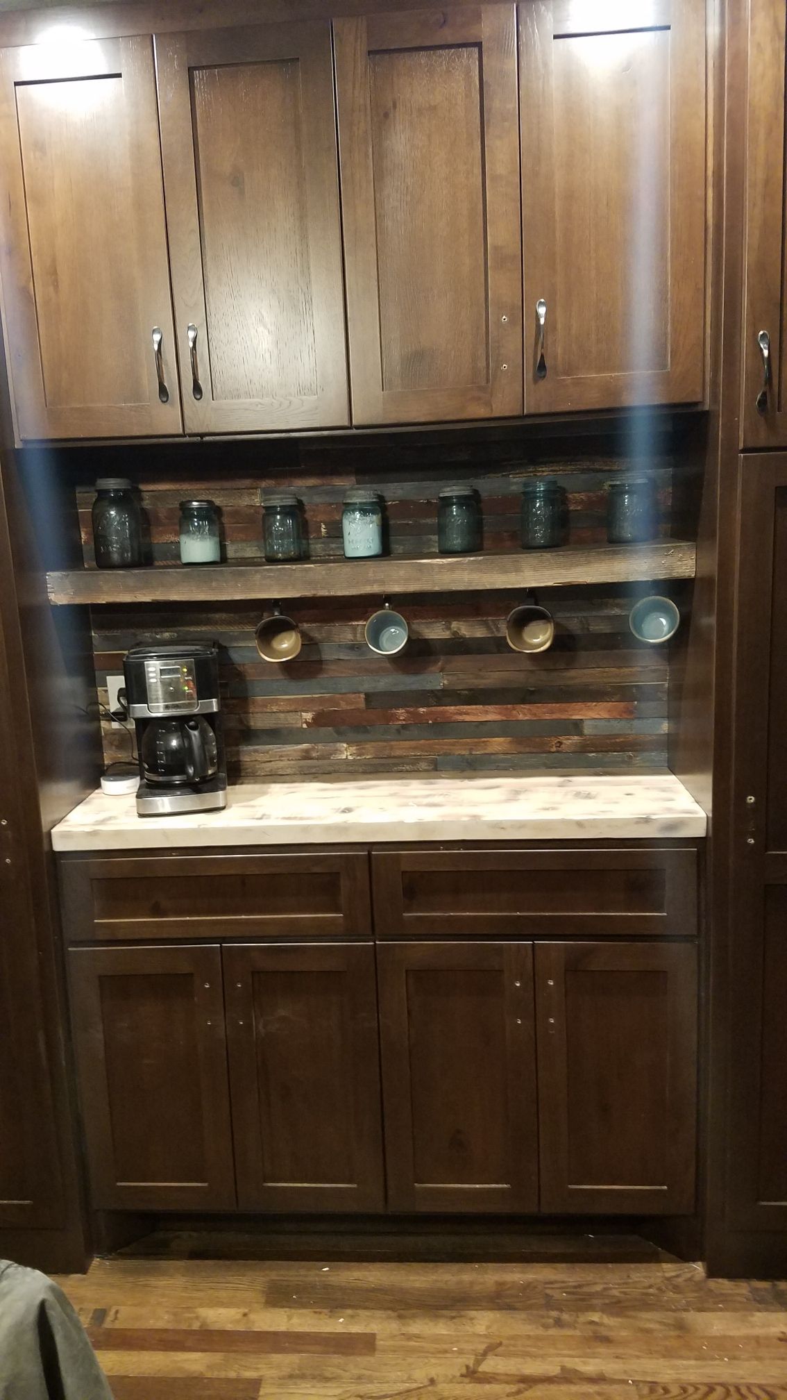 A kitchen with wooden cabinets and a coffee maker on the counter.