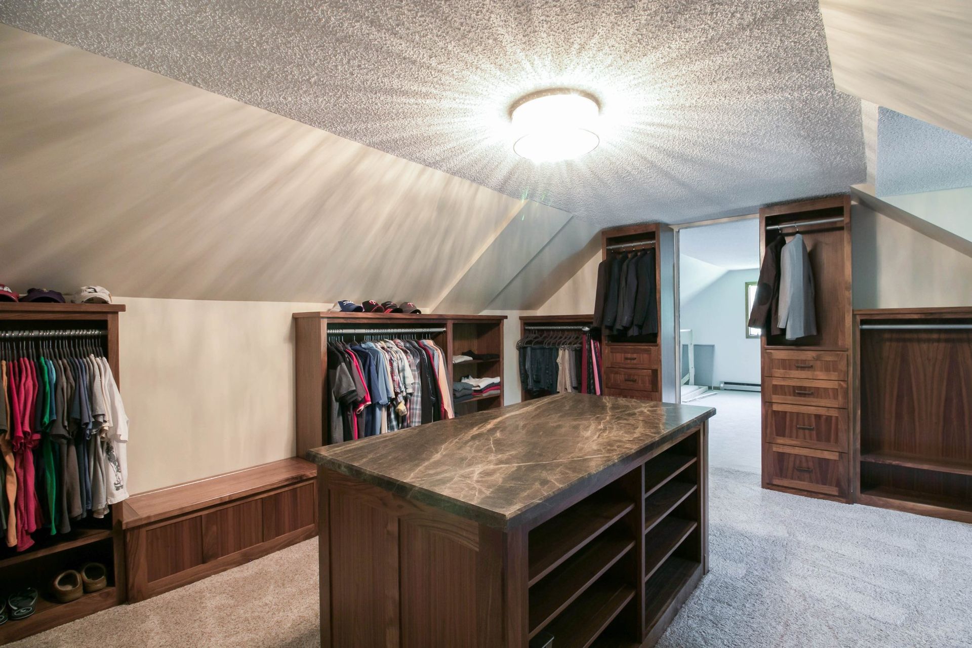 A walk in closet with a large island in the middle.