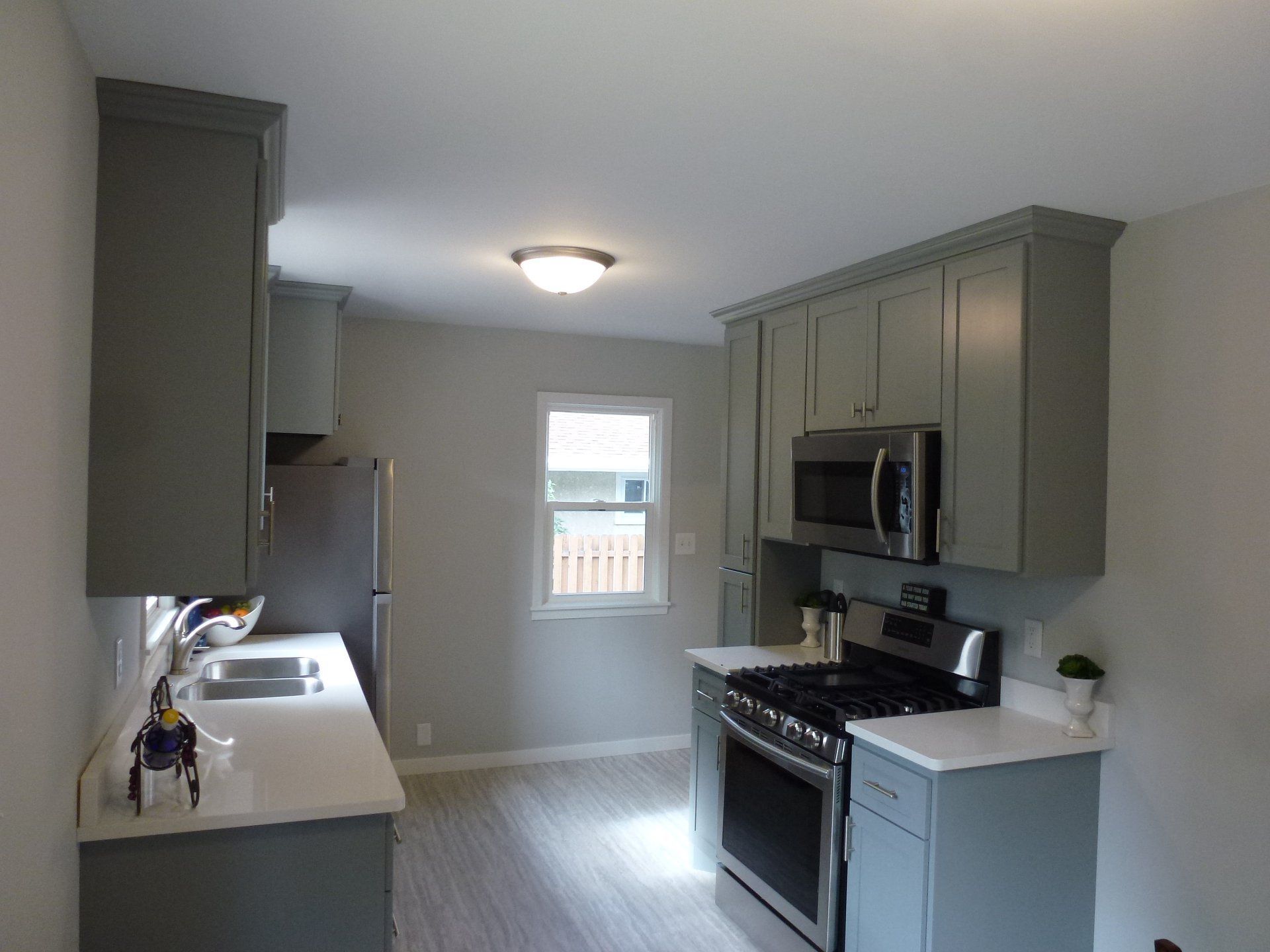 A kitchen with stainless steel appliances and gray cabinets