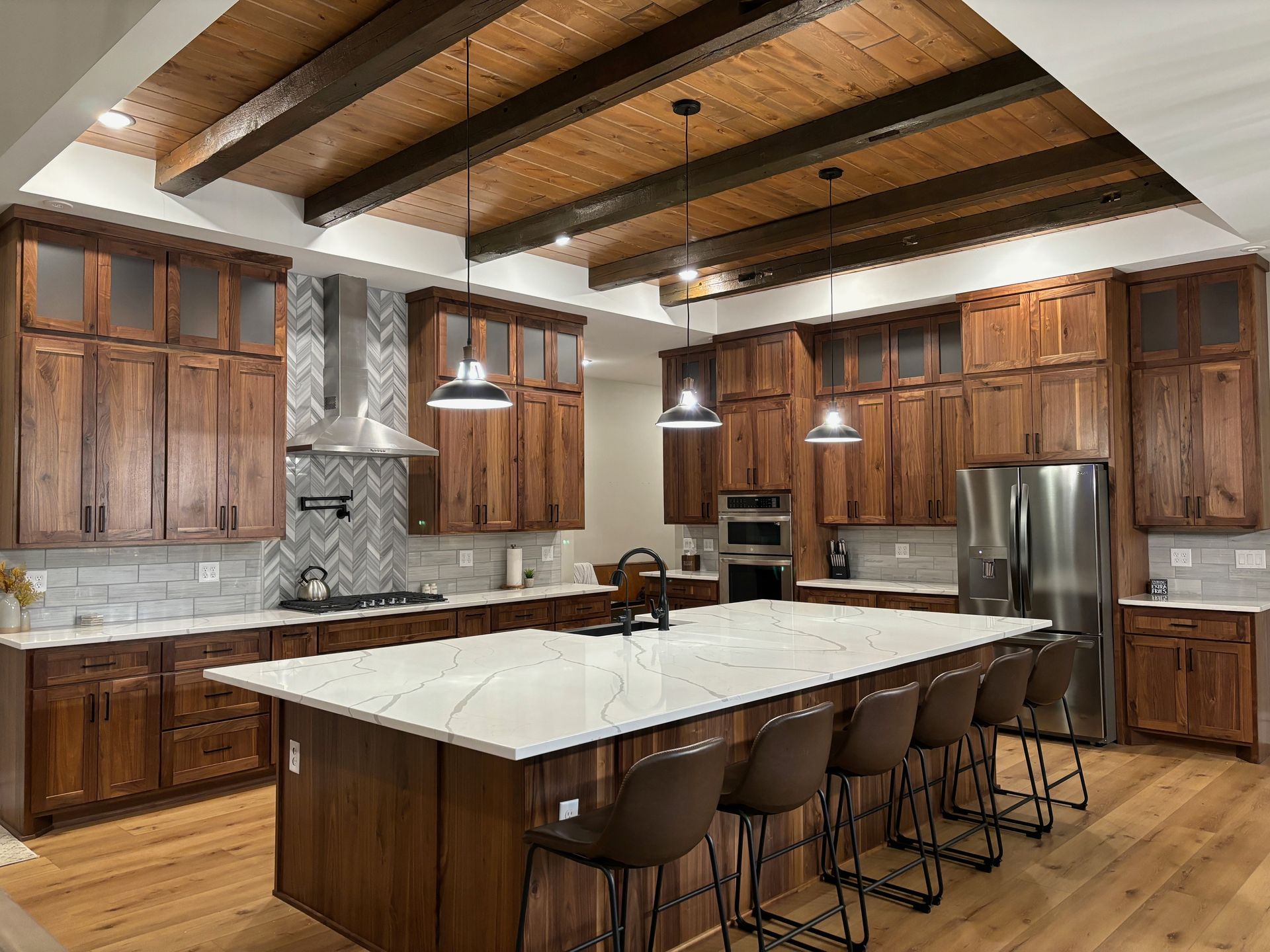 A kitchen with wooden cabinets , stainless steel appliances , and a large island.