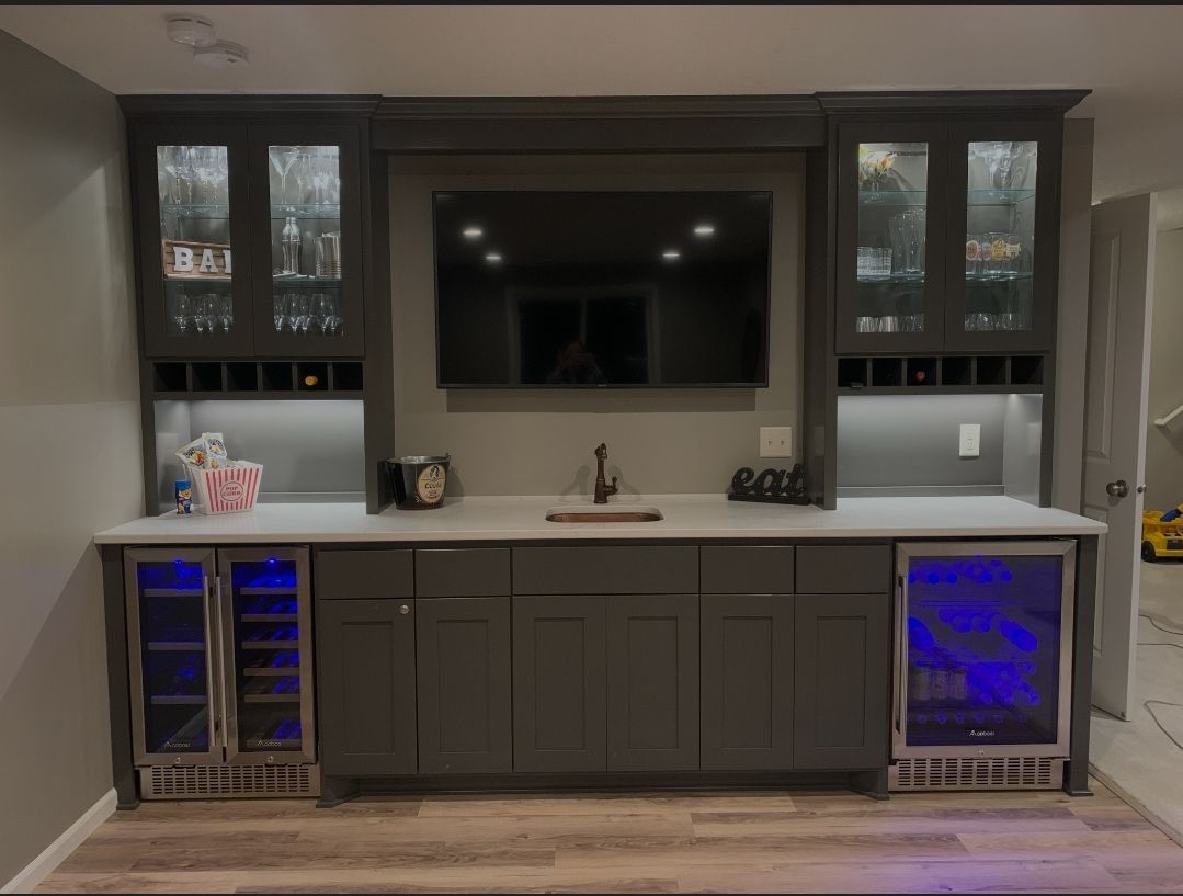 A kitchen with a sink , refrigerator , and television.
