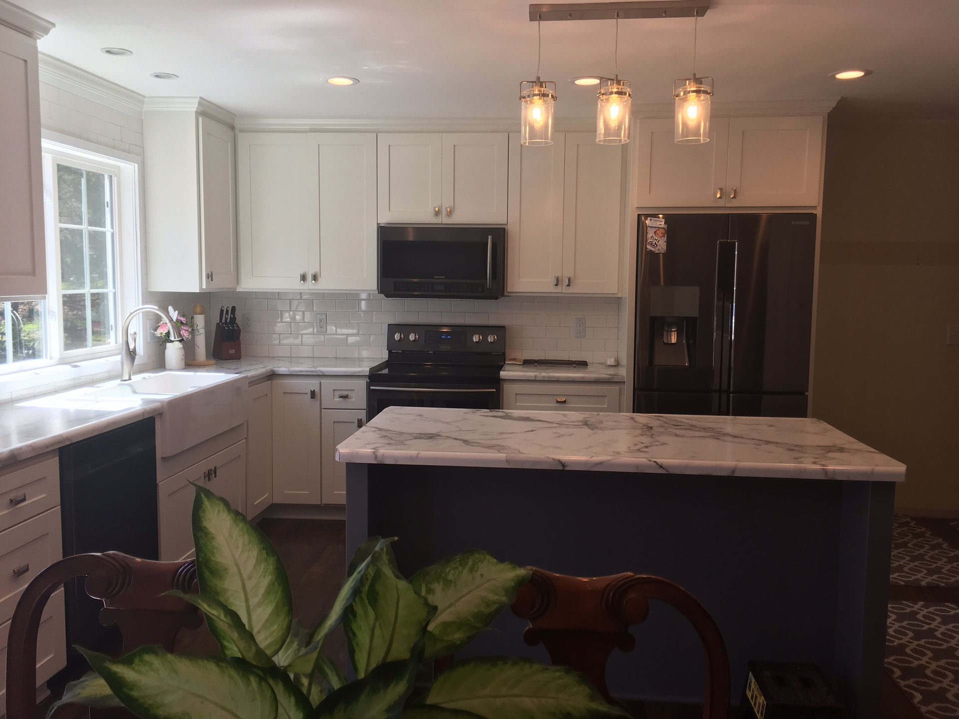 A kitchen with white cabinets and a black refrigerator