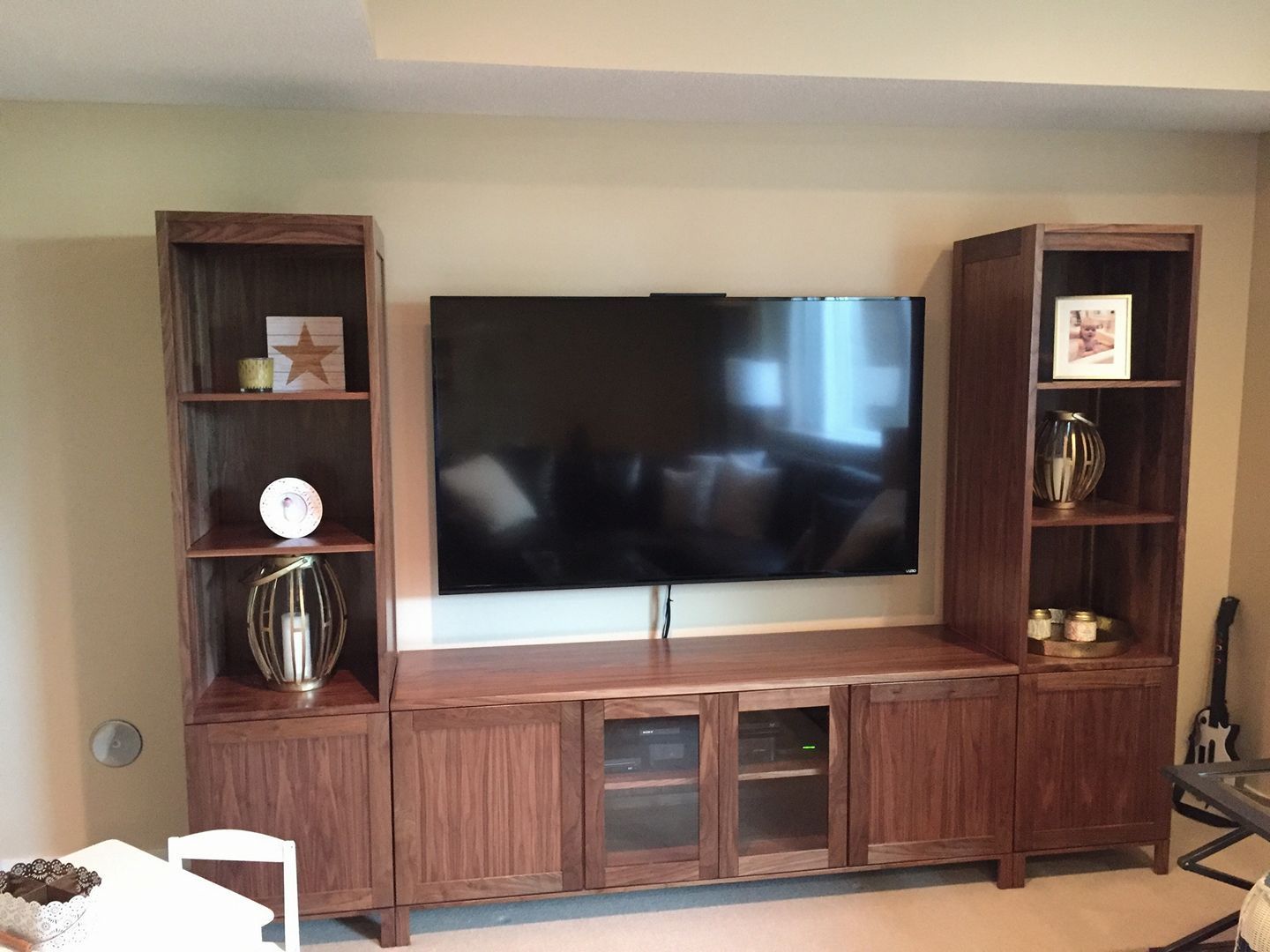 A living room with a flat screen tv on a wooden entertainment center