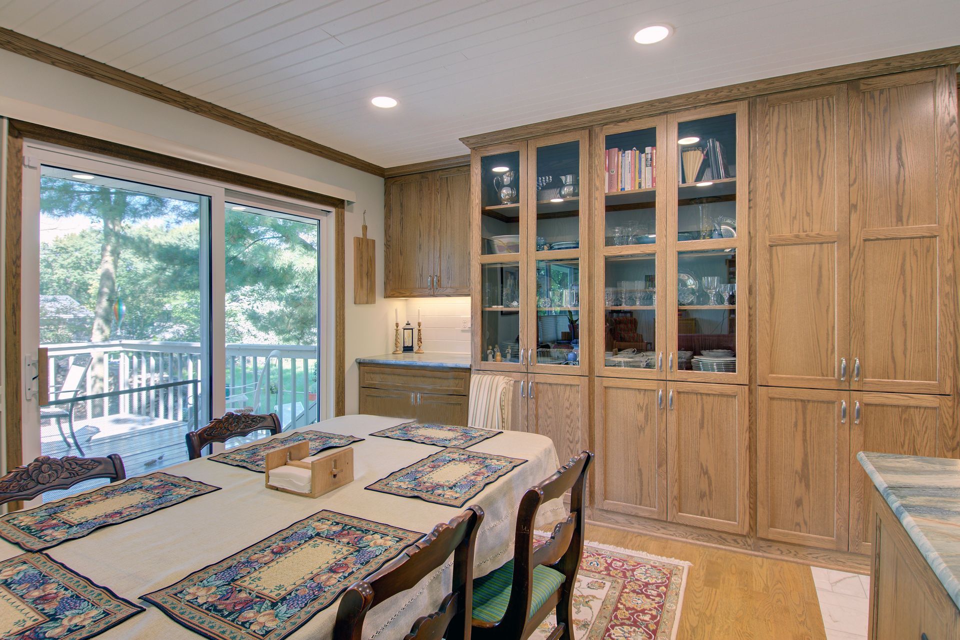 A dining room with a table and chairs and a sliding glass door.