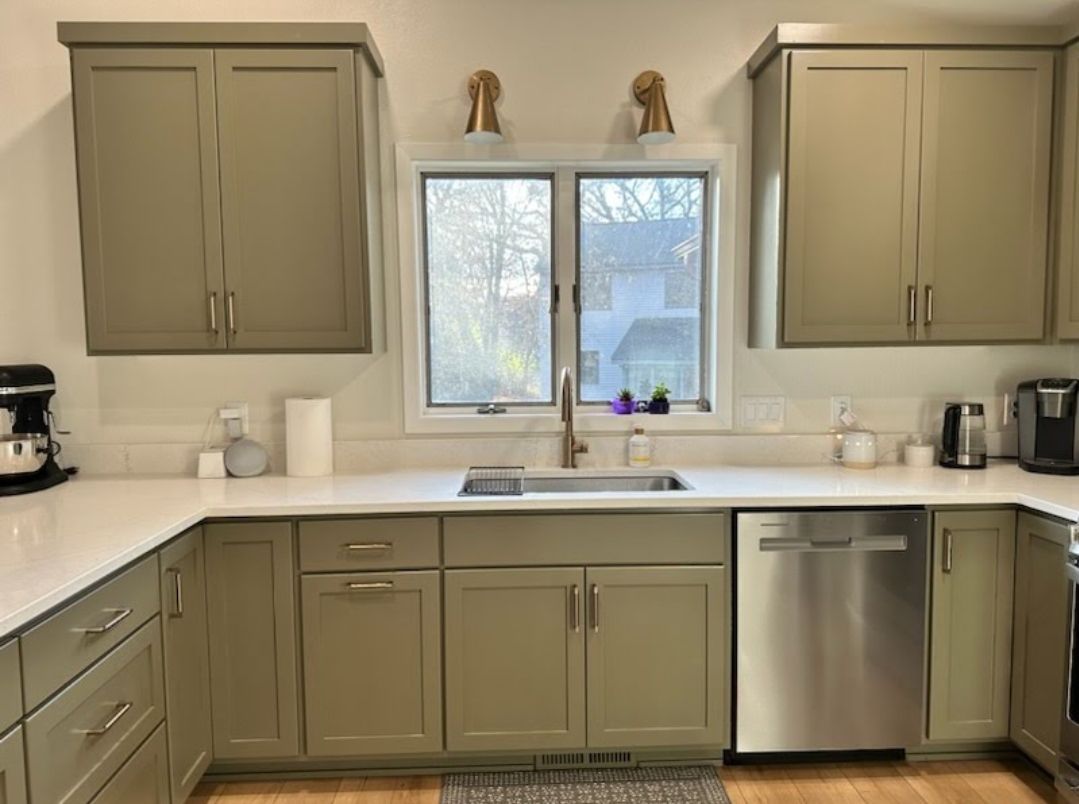 A kitchen with gray cabinets and stainless steel appliances