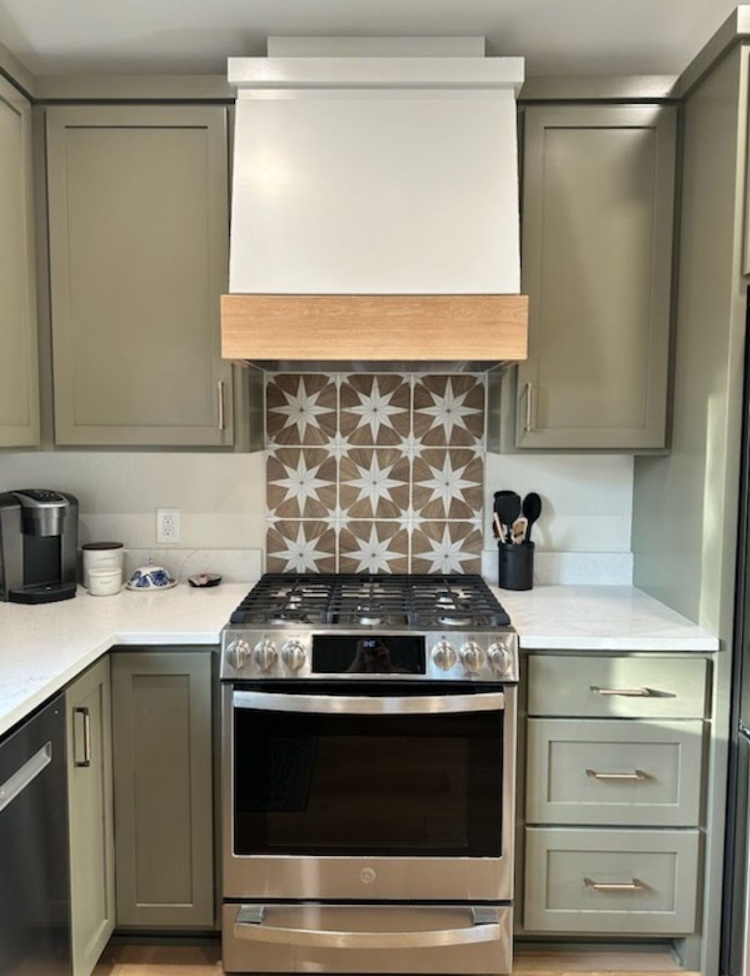 A kitchen with stainless steel appliances and green cabinets