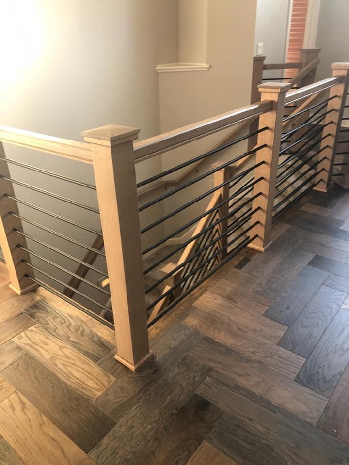 A wooden staircase with a metal railing and a wooden floor.