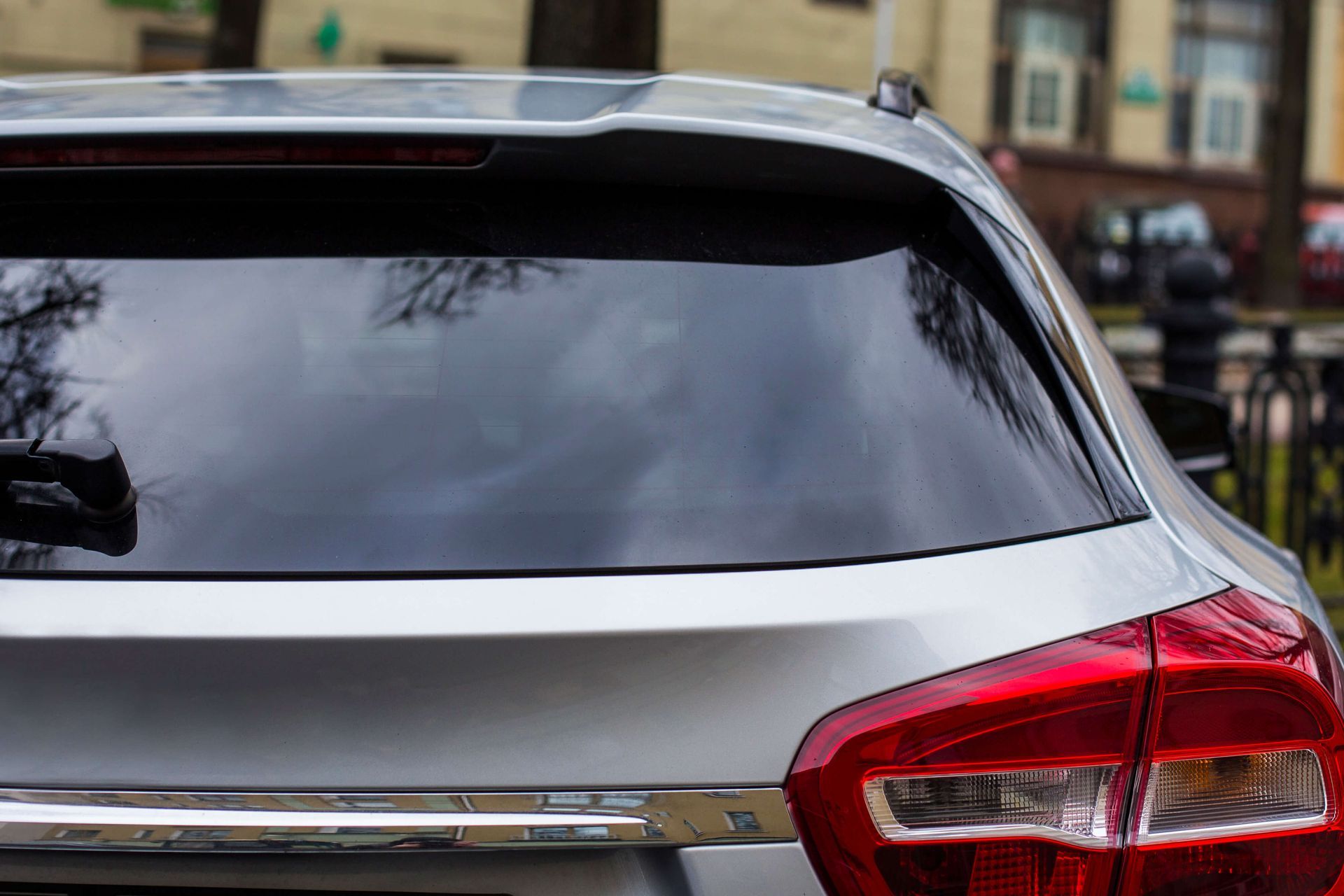 Rear view of a silver SUV with tinted back window and red taillight