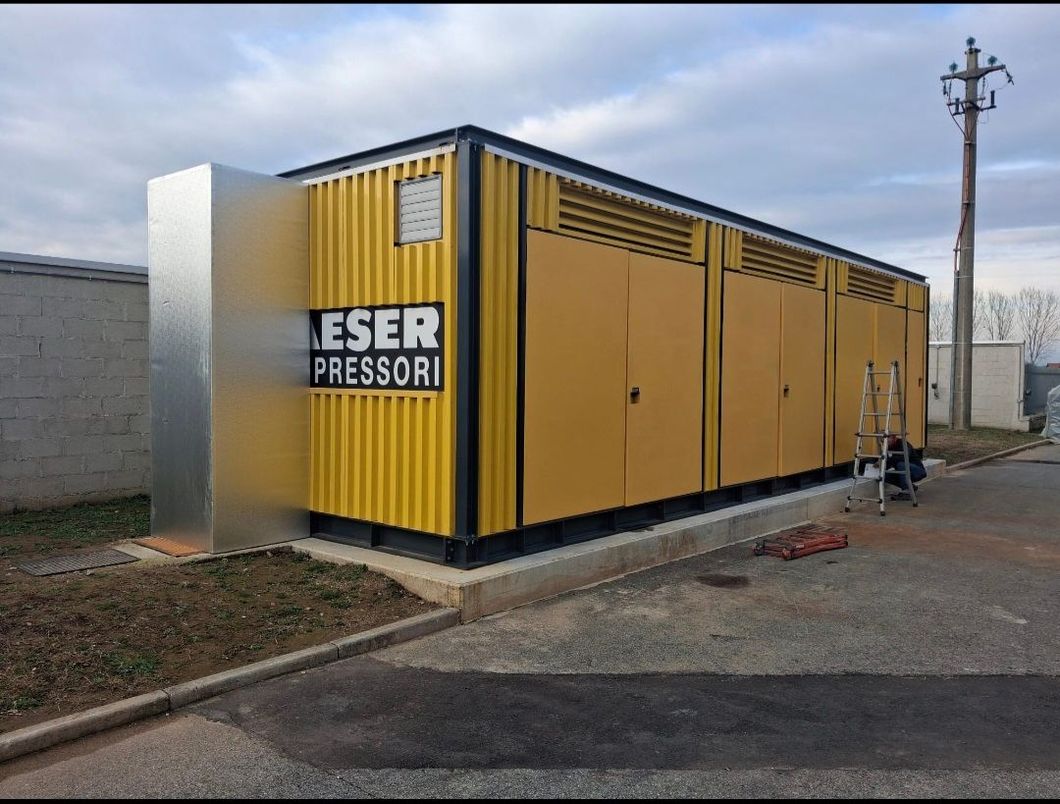 Edificio industriale giallo e nero con la scritta "ESER PRESSORI" sulla facciata.