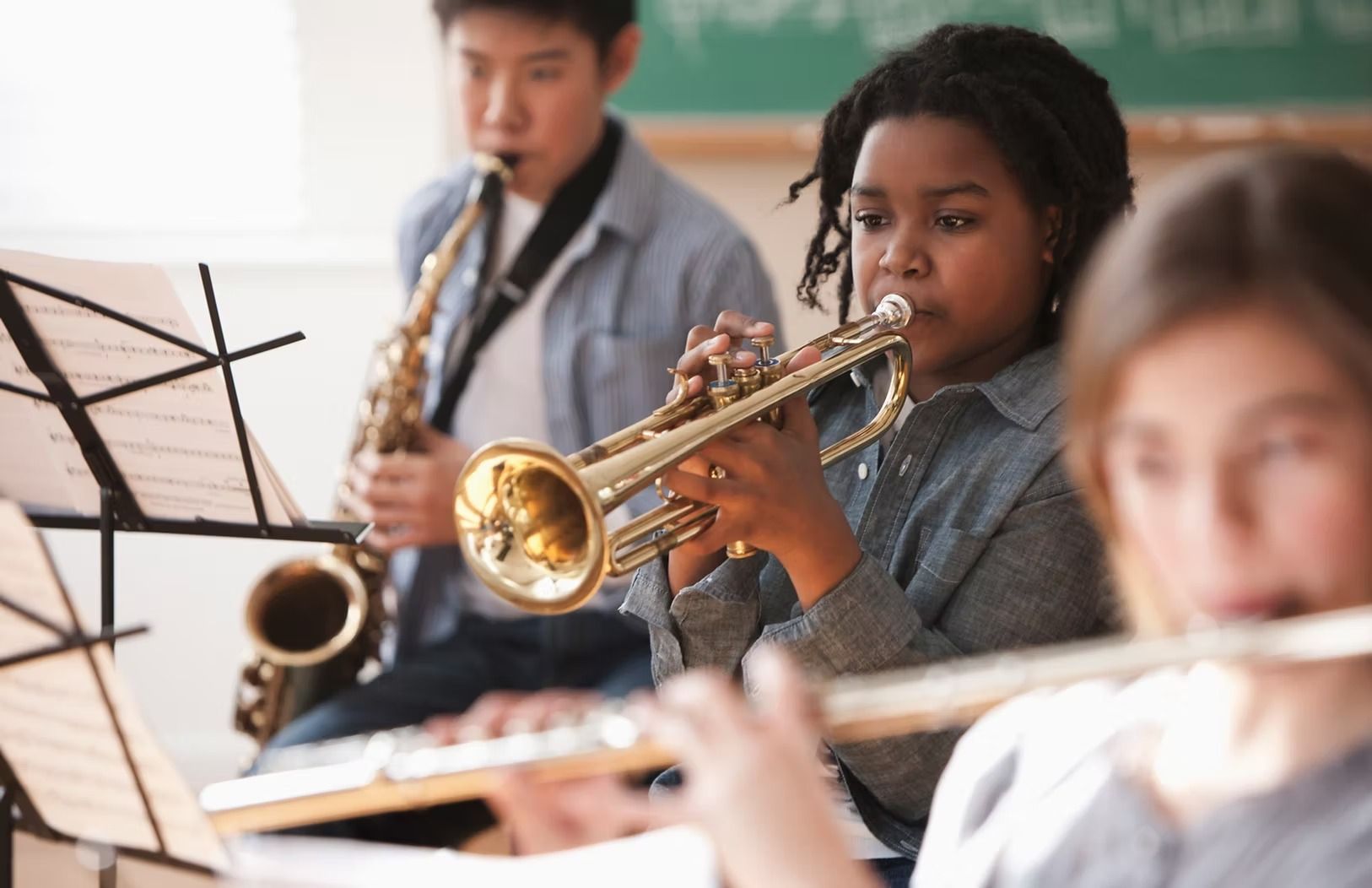 Children playing musical instruments in a classroom.