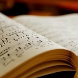 Open book of sheet music with notes visible.