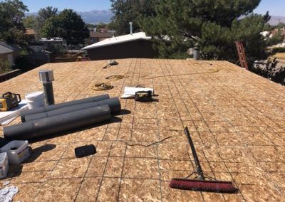 A broom is sitting on top of a wooden roof.