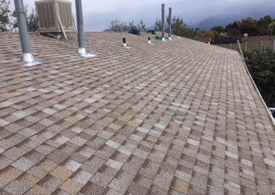 A roof with a lot of shingles and chimneys on it.