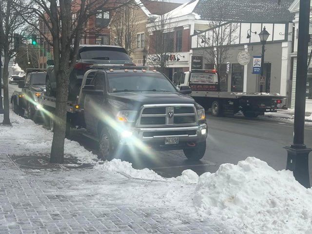 A truck is parked on the side of the road in the snow.