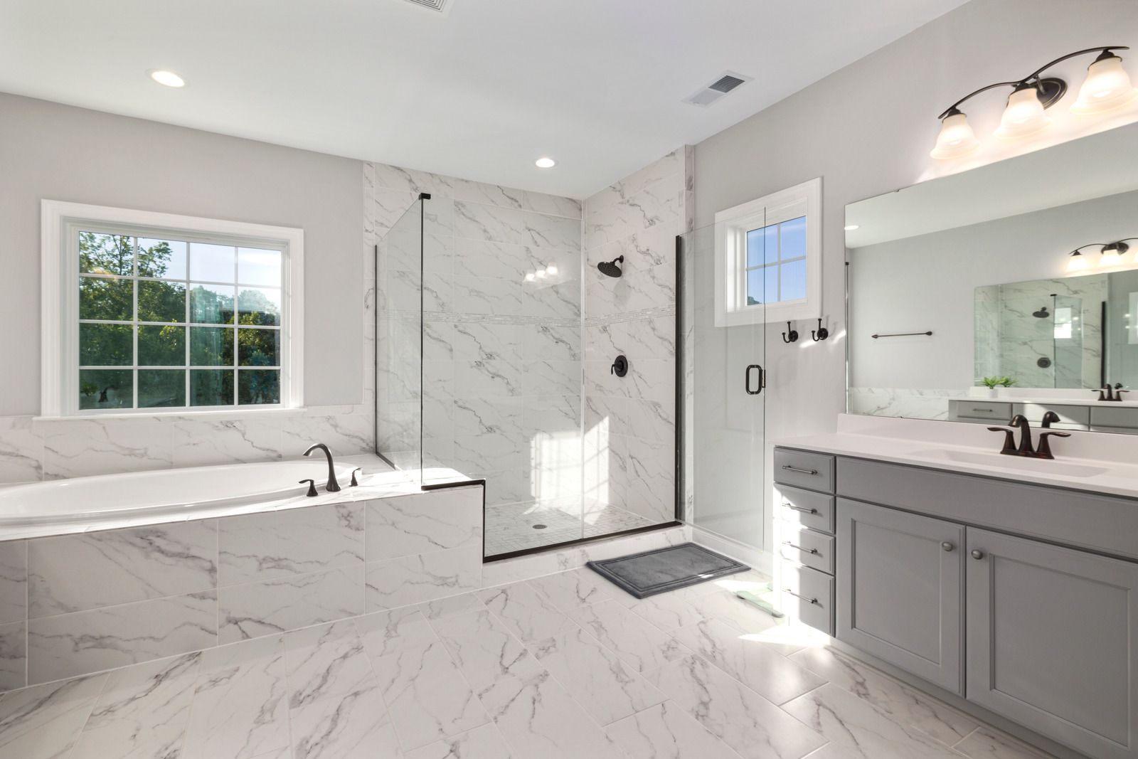 A bathroom with two sinks , a tub , and a walk in shower.
