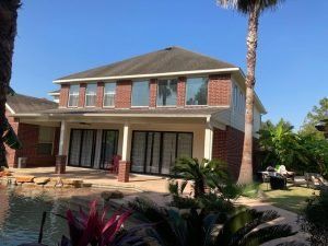A large brick house with a pool in the backyard.