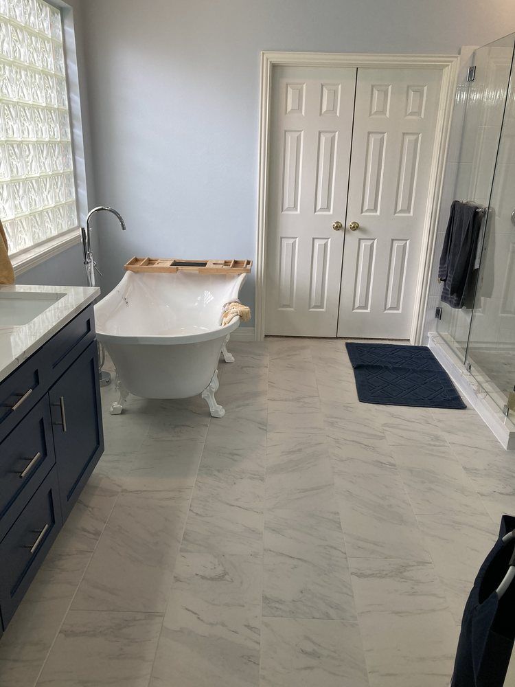A bathroom with a bathtub , sink , and shower.