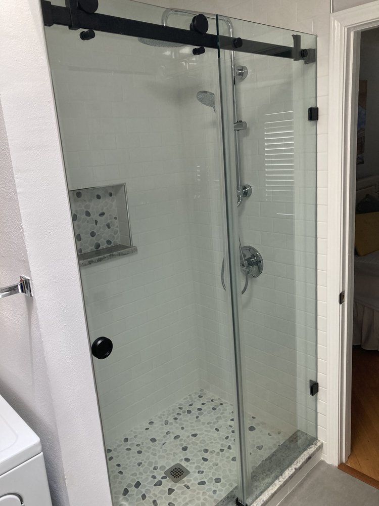 A bathroom with a sliding glass shower door.
