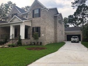 A large brick house with a truck parked in front of it.