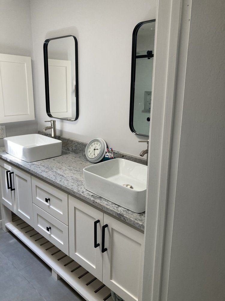 A bathroom with two sinks and two mirrors.
