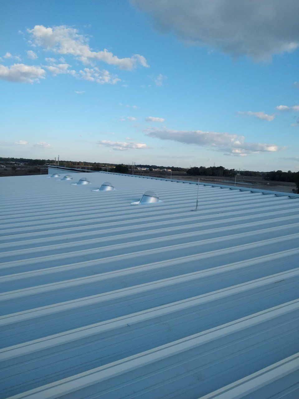 The roof of a building with a blue sky in the background