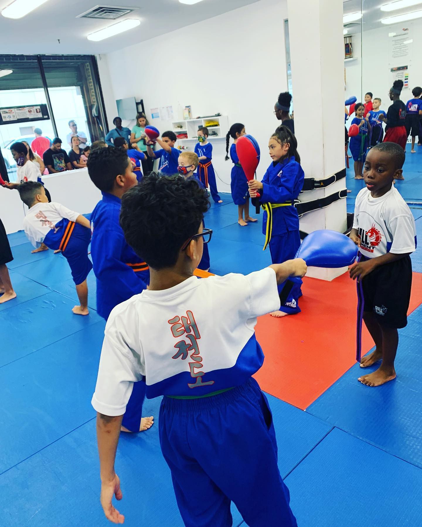 a group of young boys are practicing martial arts in a gym