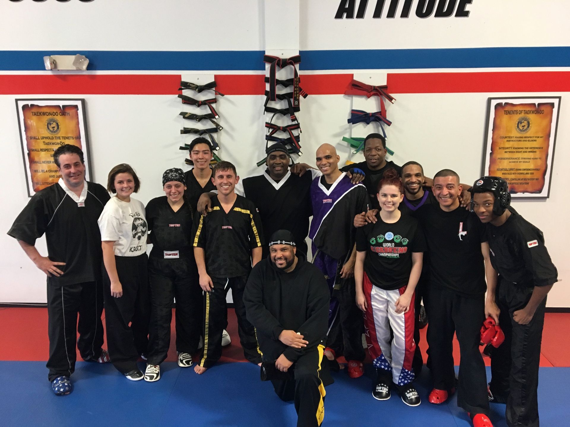 a group of people posing for a picture in front of a sign that says attitude