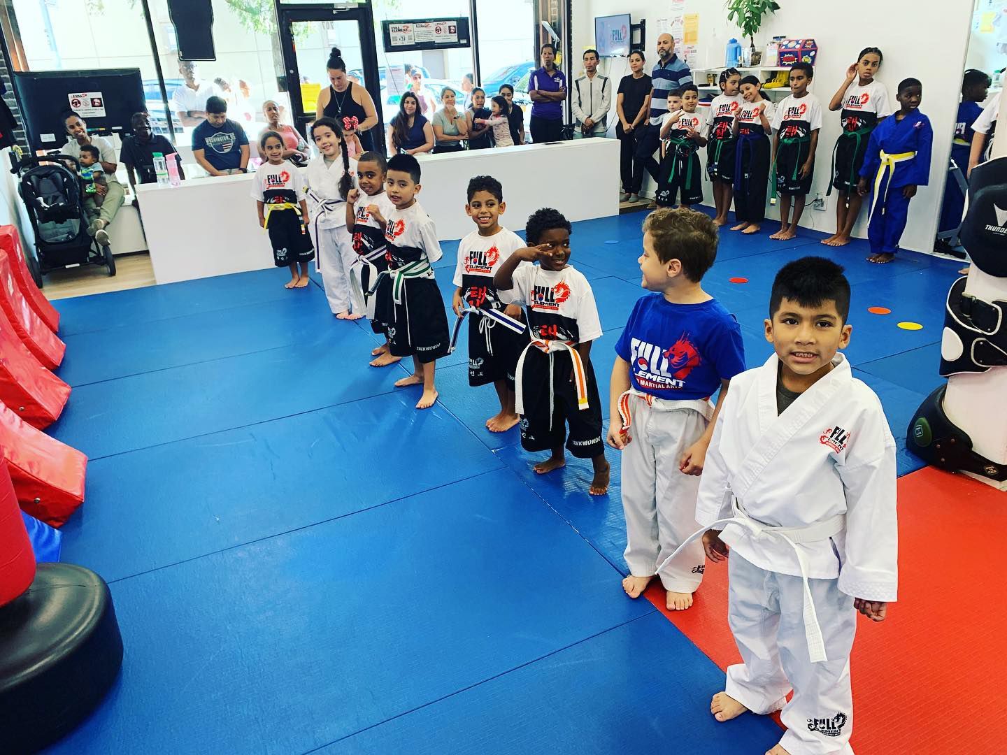a group of kids are standing in a gym wearing shirts that say full