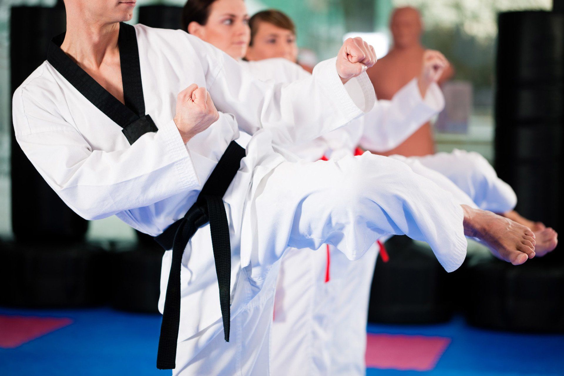 a group of people are practicing martial arts in a gym .