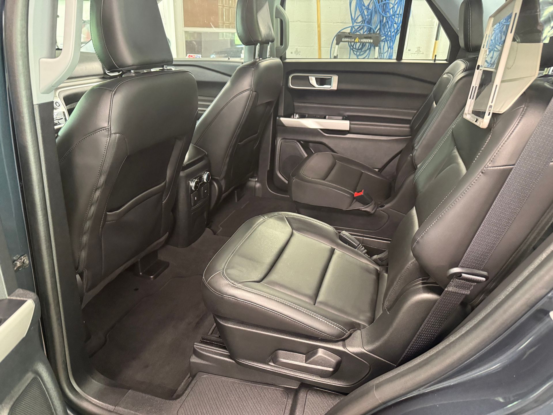 A close up of the back seat of a car with seat belts.