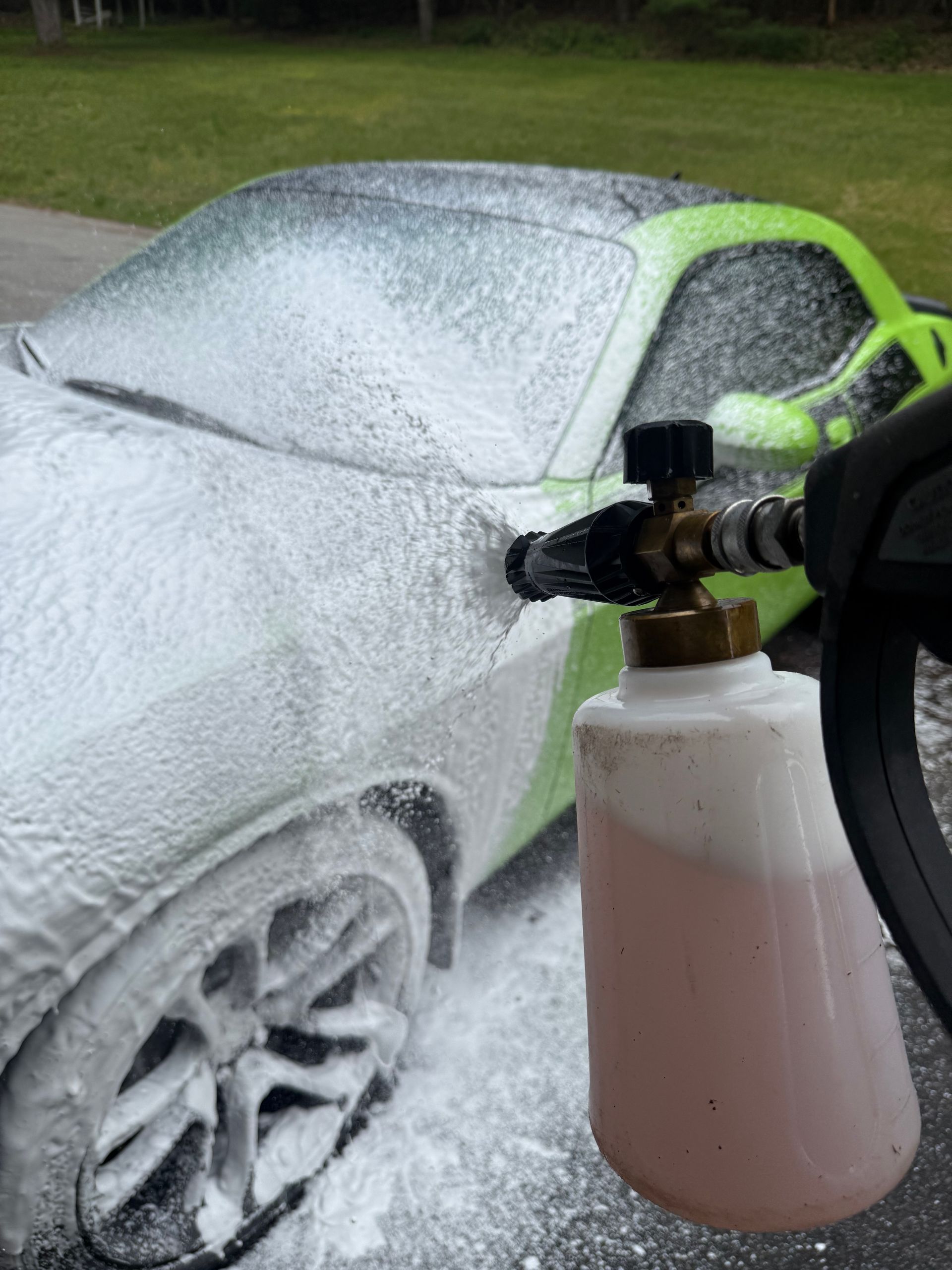 A person is cleaning a car wheel with a brush.