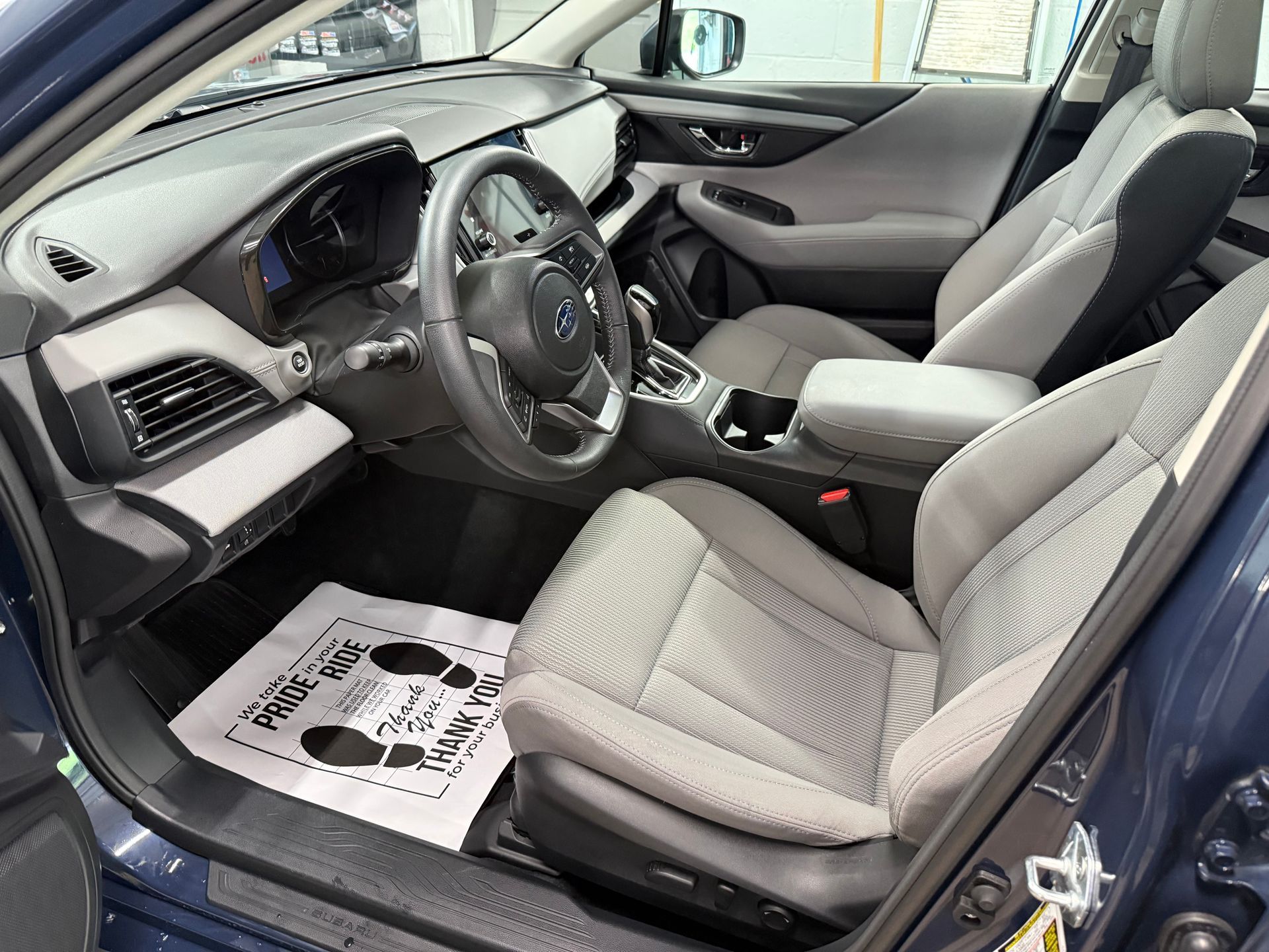 A person is cleaning the interior of a car with a brush.