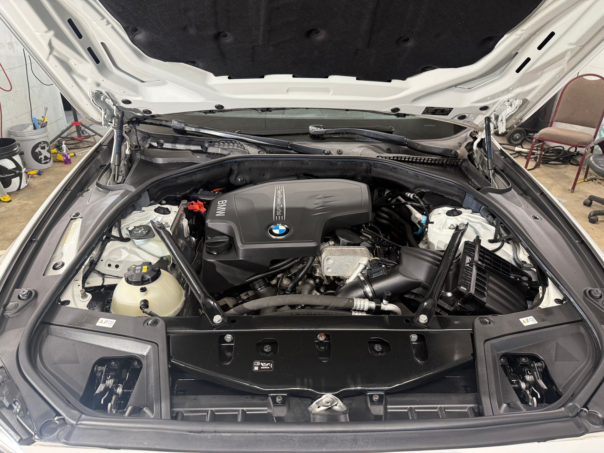 A close up of a car engine with the hood open.