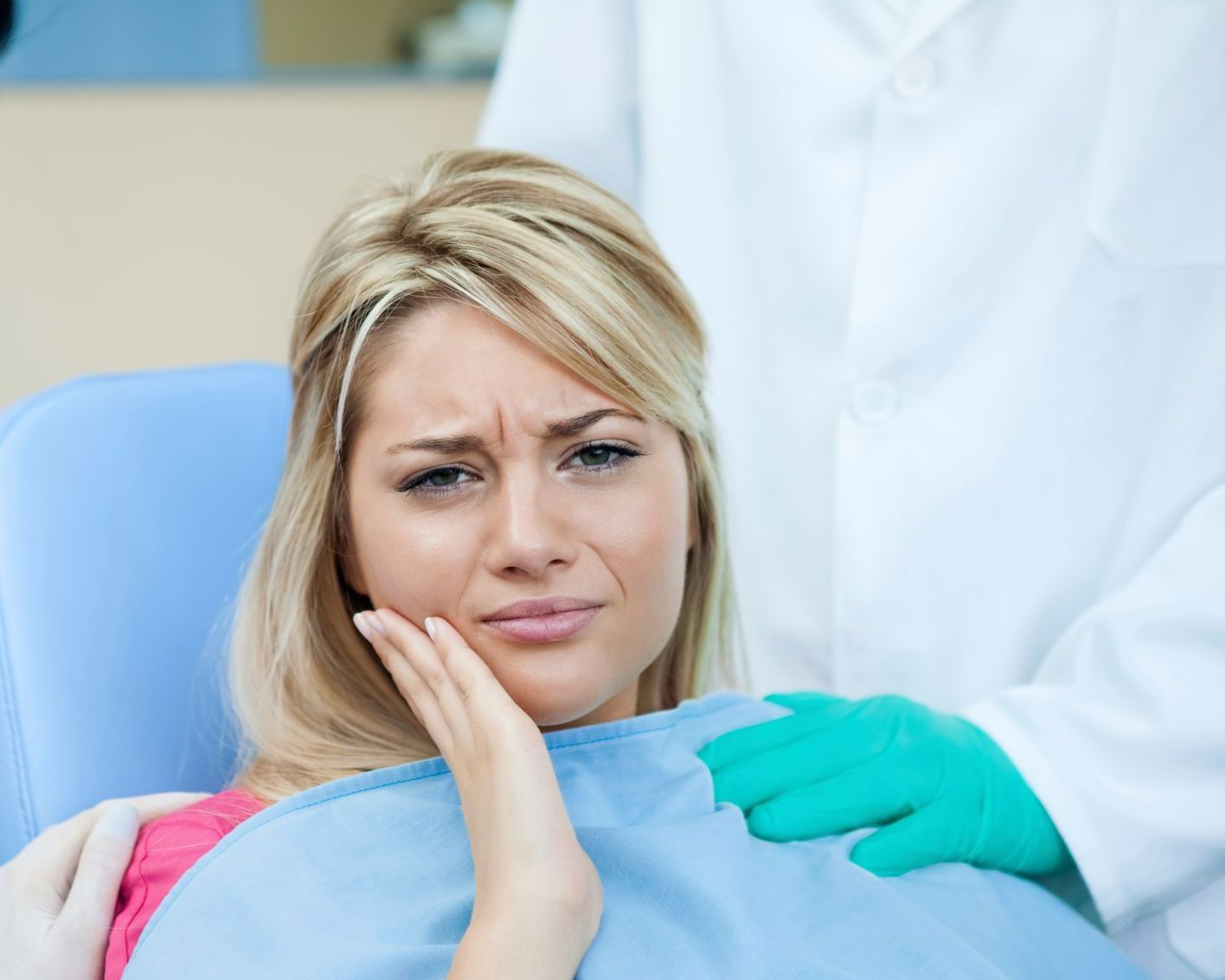 A patient having a toothache at an emergency dentist's office, while the dentist takes notes.