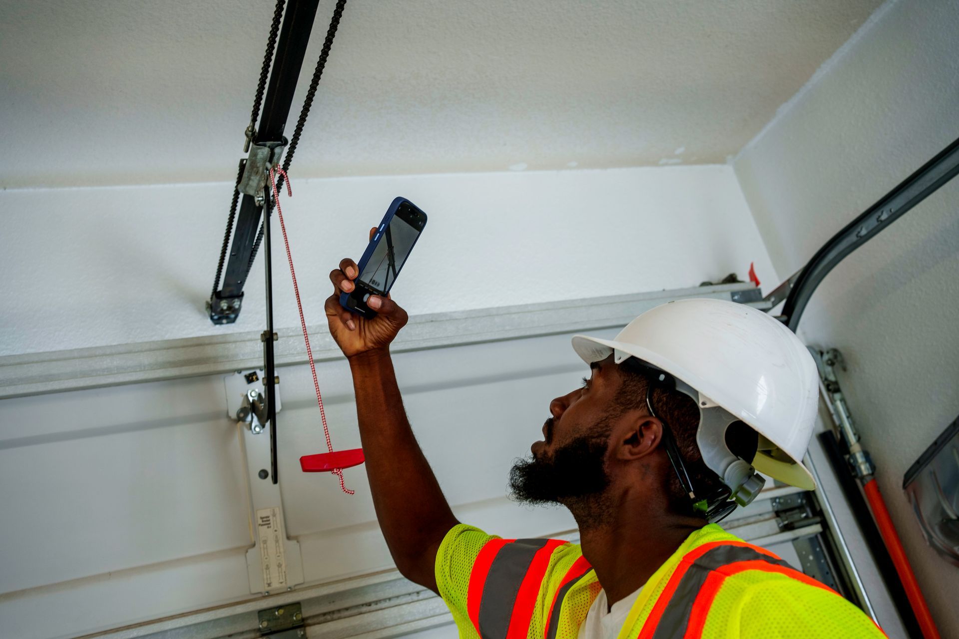 Repairman inspecting garage door mechanism.