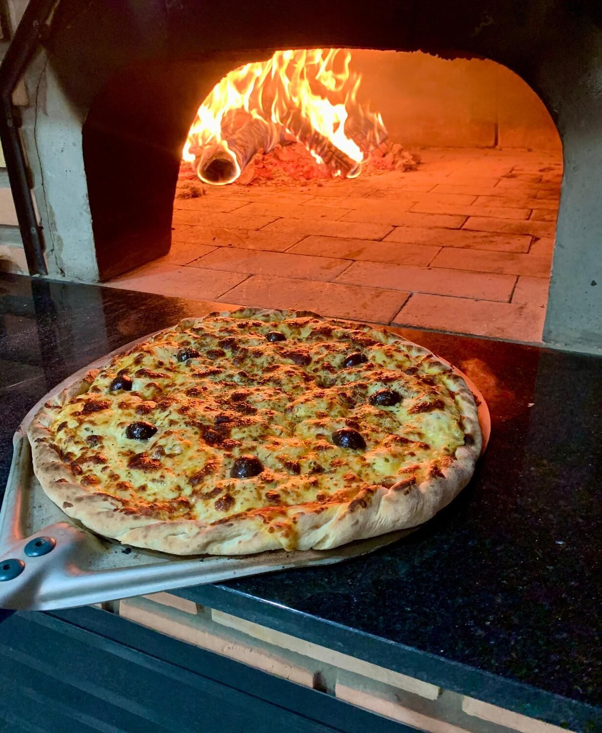 Uma grande sala de jantar com mesas e cadeiras em um restaurante.