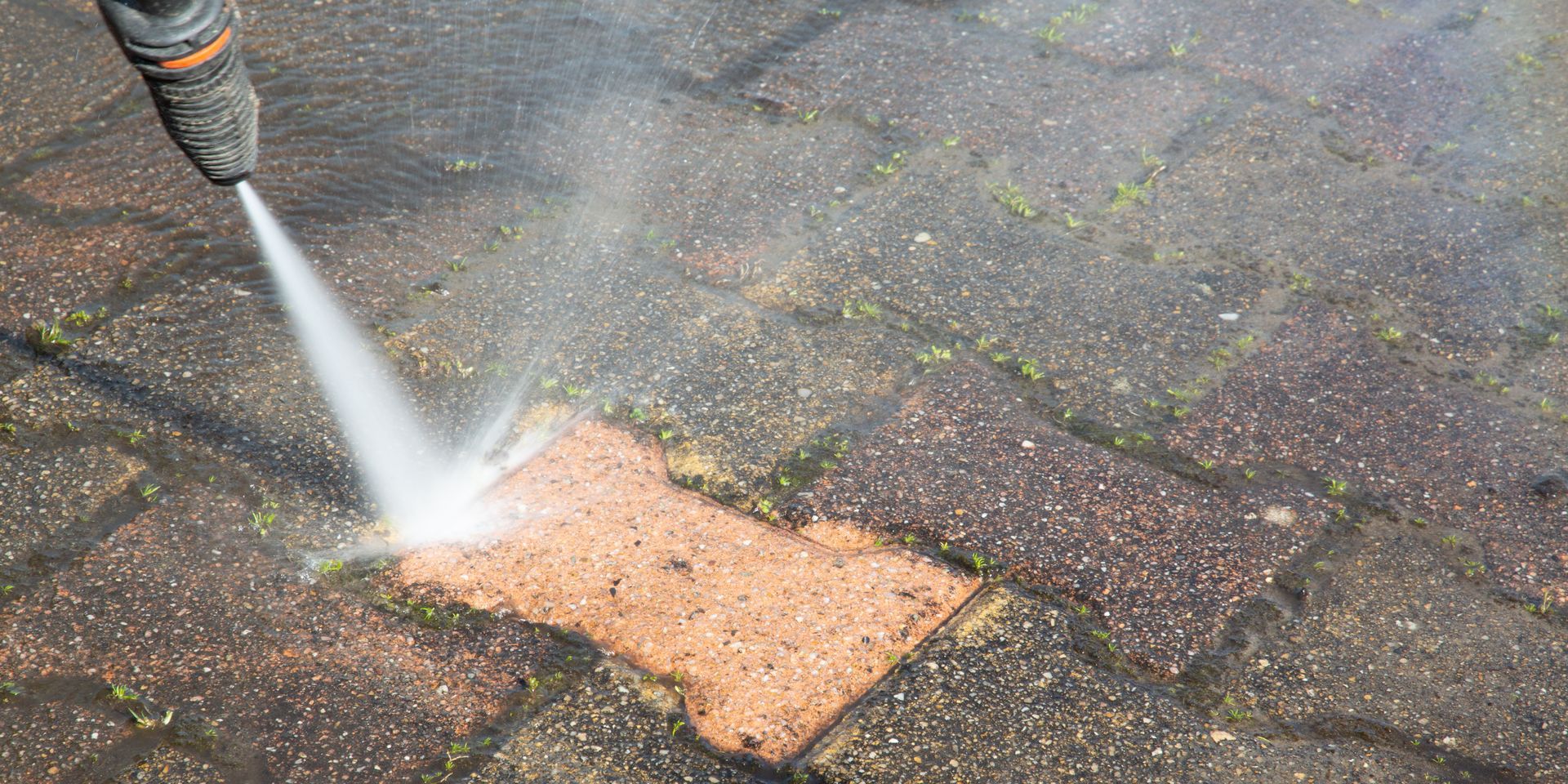 A skilled handyman using a high-pressure power washer to clean the surface.