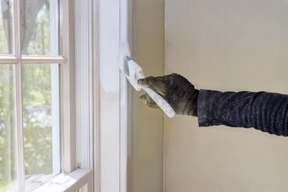 A person is painting a window with a brush.