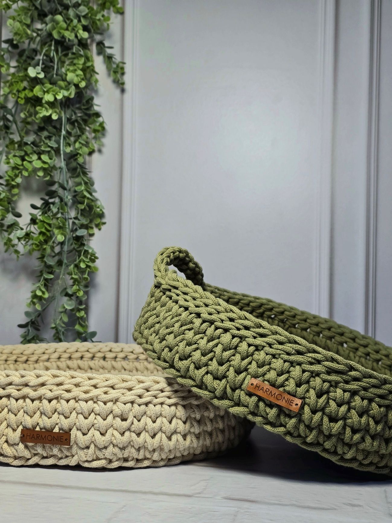 Dos cestas de crochet, una beige y otra verde oliva, con asa.