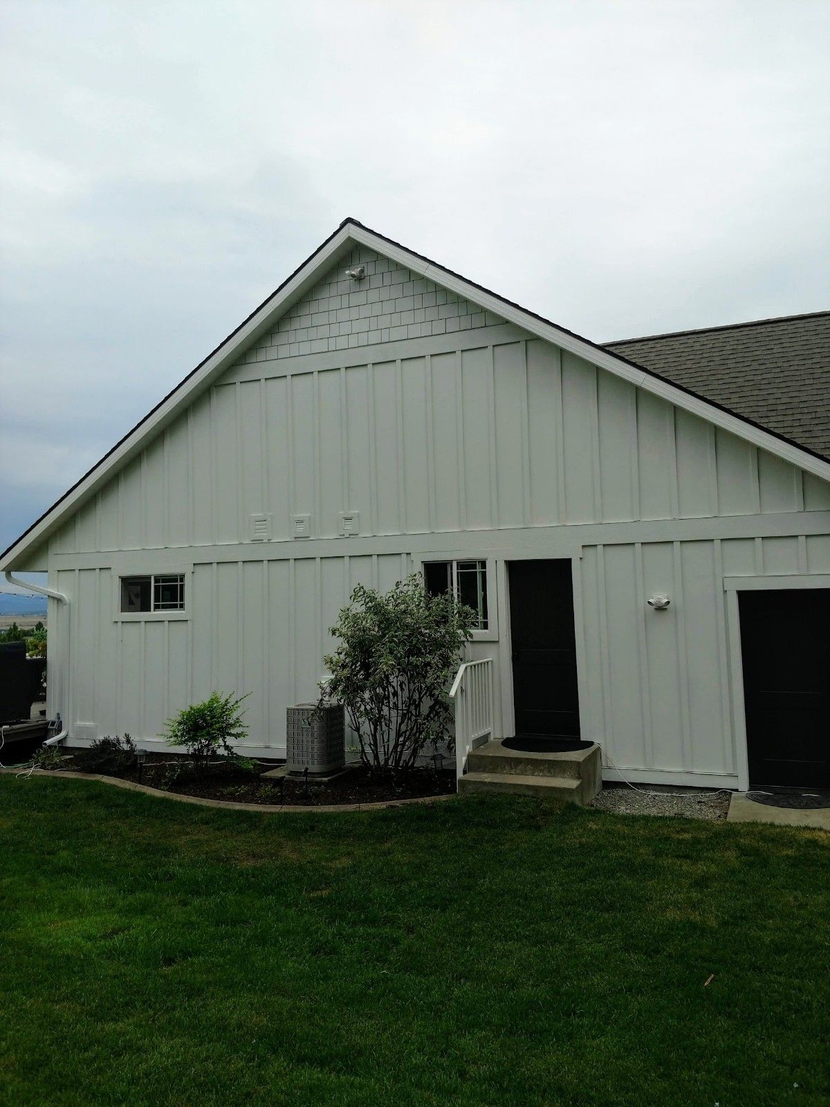 A white house with a black door and a gray roof