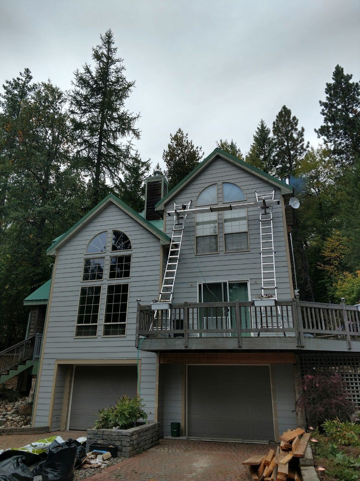 A large house with a green roof is being painted.